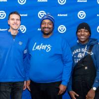 Group of five Grand Valley staff and alumni in front of backdrop